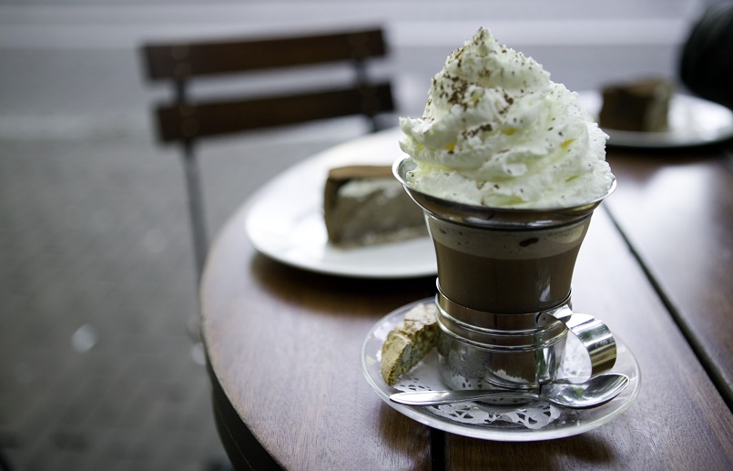 CHOCOLAT Coffee cup with whipped cream topping on table